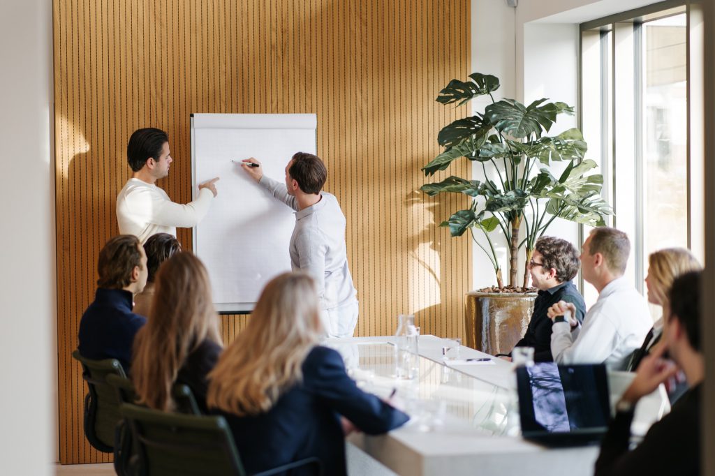 Teamoverleg bij LUCRATIEF met presentatie op whiteboard