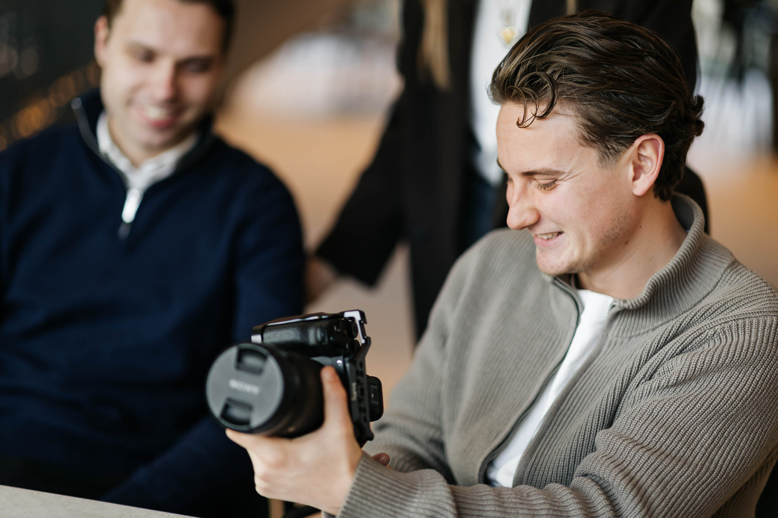 Teamleden van LUCRATIEF bekijken een camera tijdens een fotoshoot